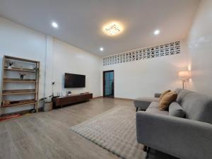a living room with a couch and a flat screen tv at Ama'home in Hat Yai