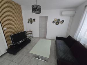 a living room with a couch and a table at Le cocon de mag in Miramas +2 photos
