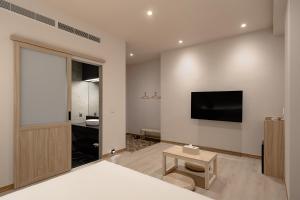 a bedroom with a bed and a television on the wall at HOYU INN's in T'ien-liao