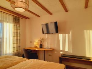 a bedroom with a bed and a tv on the wall at Gasthof Siebenstern in Röslau