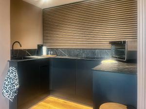 a kitchen with black cabinets and a microwave at The Foxes Hole - Uk49085 in Winewall