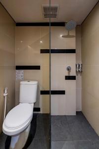 a bathroom with a toilet and a glass shower at Tusita Boutique Hotel in Kuta +23 photos