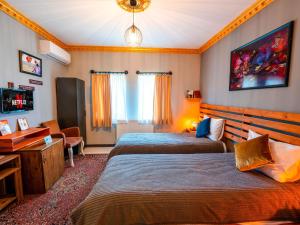 a hotel room with two beds and a desk at Alpha Stone House in Göreme