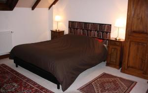 a bedroom with a bed and two night stands with lamps at La Grange de Jeanne in Moosch