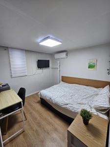 a bedroom with a bed and a tv and a table at 부천역 감성 숙소 in Samgong