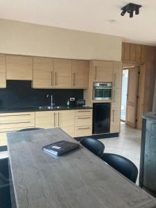 a kitchen with a table and chairs and a kitchen with a stove at De Notelaar in Alveringem +13 photos