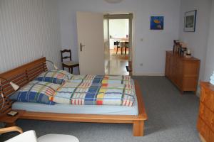 - une chambre avec un lit et une commode en bois dans l'établissement Timmermannshof, à Xanten