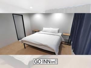 a bedroom with a bed with white sheets at xx GO INN Phuket Old Town in Phuket
