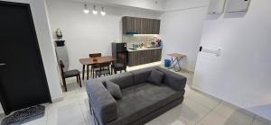 a living room with a couch and a kitchen at Setia Alam Homestay - Quiet High-Floor Studio in Shah Alam