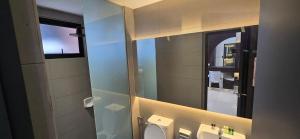 a bathroom with a mirror and a toilet and a sink at Setia Alam Homestay - Quiet High-Floor Studio in Shah Alam