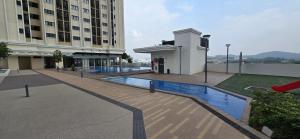 a building with a swimming pool in front of a building at Setia Alam Homestay - Quiet High-Floor Studio in Shah Alam +18 photos
