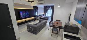 a living room with a couch and a tv at Setia Alam Homestay - Quiet High-Floor Studio in Shah Alam