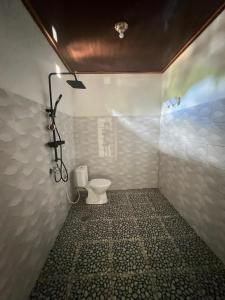 a bathroom with a toilet and a shower at Andre Homestay in Kuta Lombok