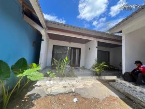 a man sitting on the porch of a house at Andre Homestay in Kuta Lombok