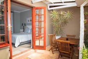 a bedroom with a bed and a table and chairs at Bayside Guesthouse in Port Elizabeth