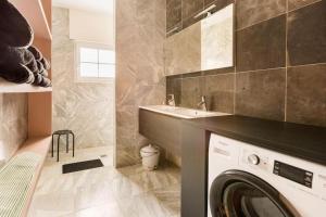 a bathroom with a washing machine and a sink at De Notelaar in Alveringem