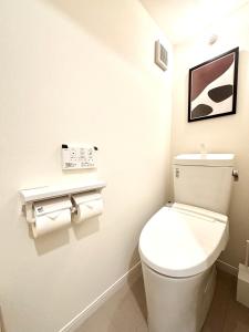a bathroom with a white toilet and a picture on the wall at Hal Kokubunji in Kokubunji