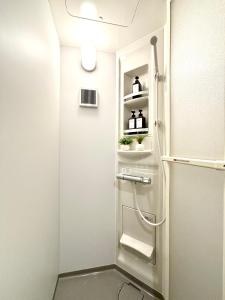a shower in a bathroom with a door and shelves at Hal Kokubunji in Kokubunji +39 photos