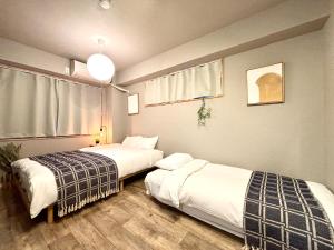 two beds sitting in a room with at Hal Kokubunji in Kokubunji