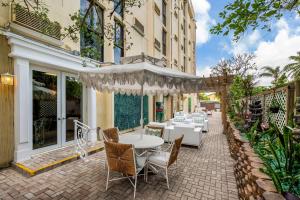 a patio with a white table and chairs at Comfort Inn Oceanside Deerfield Beach in Deerfield Beach