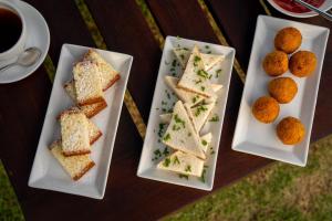 a table with three plates of sandwiches and a cup of coffee at Villa Tanderra in Tangalle