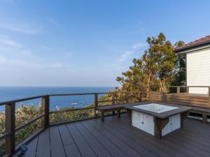 a wooden deck with a bench on top of the ocean at The THERM in Munakata