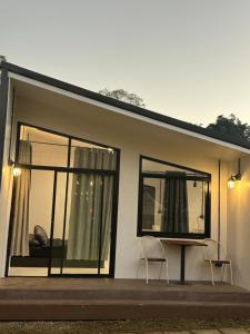 a house with two chairs and a table in front of it at Inthanon Mountain Camp in Ban Na Yang