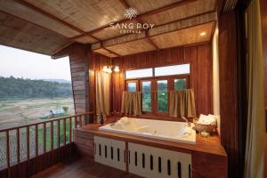 a large bathroom with a tub on a balcony at Sang Poy Cottage in Ban Kung Mai Sak