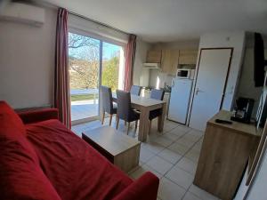 a living room with a couch and a table and a kitchen at Appartement dans résidences de vacances in Salavas