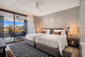 two beds in a hotel room with a balcony at Angsana Oceanview Residences Building 2 in Laguna by Banyan Living in Bang Tao Beach +47 photos