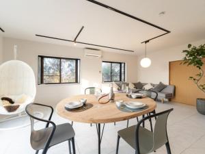 a dining room and living room with a wooden table and chairs at The THERM in Munakata