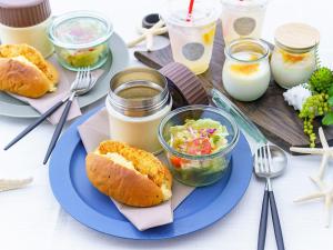 a blue plate of food with a sandwich and salad at The THERM in Munakata