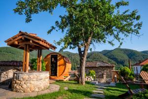 a cabin in the mountains with a tree at Villa Martina in Smilyan