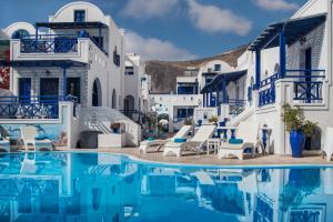 a pool with white buildings and blue water at Samson΄s Village in Perissa