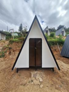 a small white tent with a door in the middle at Secret valley vattavada in Vattavada