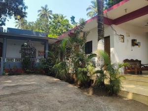 a house with palm trees in front of it at R K Guest House Arpora in Mapusa +8 photos