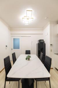 a dining room with a white table and chairs at Roots Osaka Station 2 in Osaka