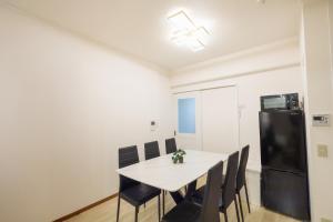 a dining room with a table and chairs and a refrigerator at Roots Osaka Station 2 in Osaka +33 photos