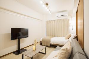 a bedroom with a bed and a tv in a room at Roots Osaka Station 2 in Osaka