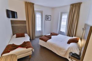 a hotel room with two beds and a tv at Hôtel de l'Europe Grenoble hyper-centre in Grenoble +5 photos