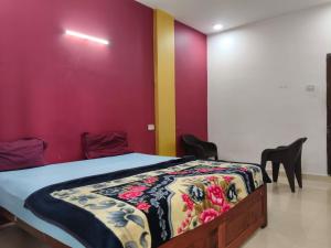 a bedroom with a bed with a colorful wall at R K Guest House Arpora in Mapusa