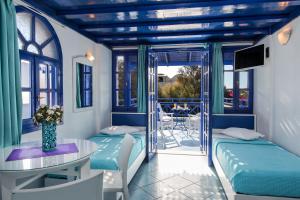 a room with two beds and a table with a table at Samson΄s Village in Perissa