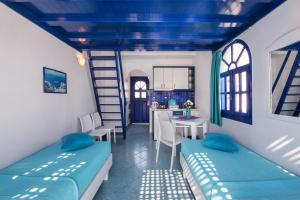 a room with two beds and a table with chairs at Samson΄s Village in Perissa