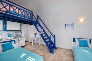 a room with two beds and a blue staircase at Samson΄s Village in Perissa