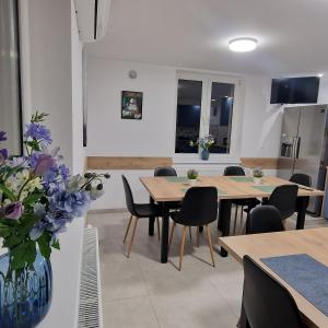 a dining room with two tables and chairs and flowers at Willa Na Białej in Ziajki