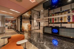 a lobby with a chair and a tv in a building at Hotel Geight Taipei in Zhonghe