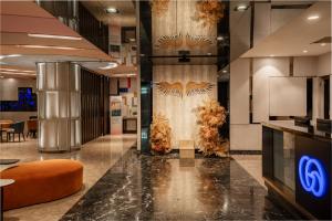 a lobby of a building with a wall with a design at Hotel Geight Taipei in Zhonghe