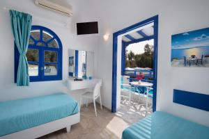 a hotel room with blue walls and blue curtains at Samson΄s Village in Perissa