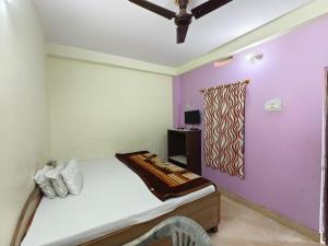 a bedroom with a bed and purple walls at Hotel Vijay in Rājgīr