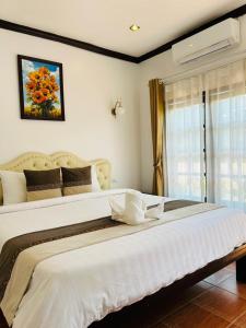 a large white bed in a bedroom with a window at Win Hotel Vang Vieng in Vang Vieng +36 photos